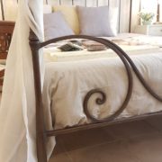 Letto in ferro battuto forgiato a mano con baldacchino in finitura ruggine.Particolare fondo letto. Arredamento contemporaneo su misura Siena e Firenze