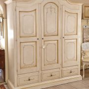 Armadio sagomato in legno di tiglio a tre ante laccato e decorato a mano con cappello mosso. Frontale. Arredamento classico contemporaneo Siena e Firenze.