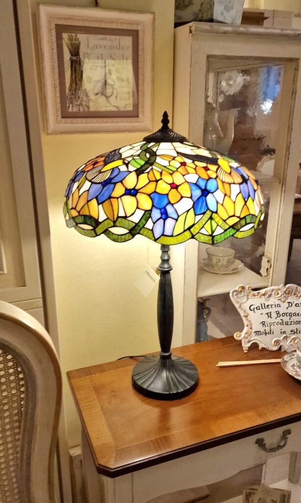 Lampada Tiffany Colibrì con base in fusione brunita. Arredamento classico contemporaneo Siena e Firenze